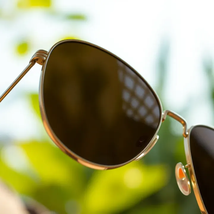 Close-up of aviator glasses highlighting metal frame and tinted lenses under natural light